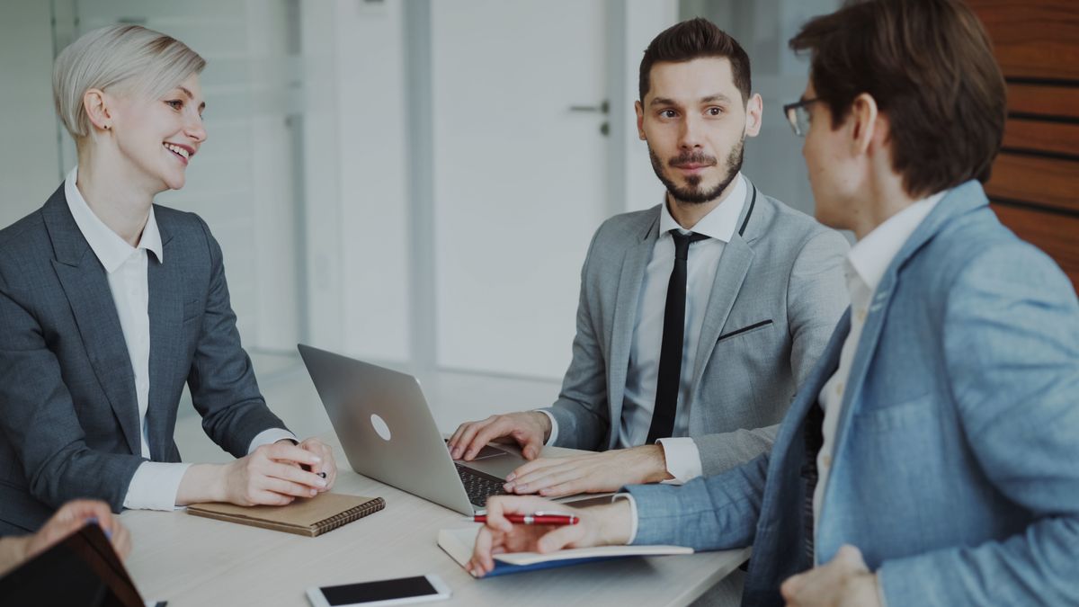 Asesores reunidos con un cliente en el despacho